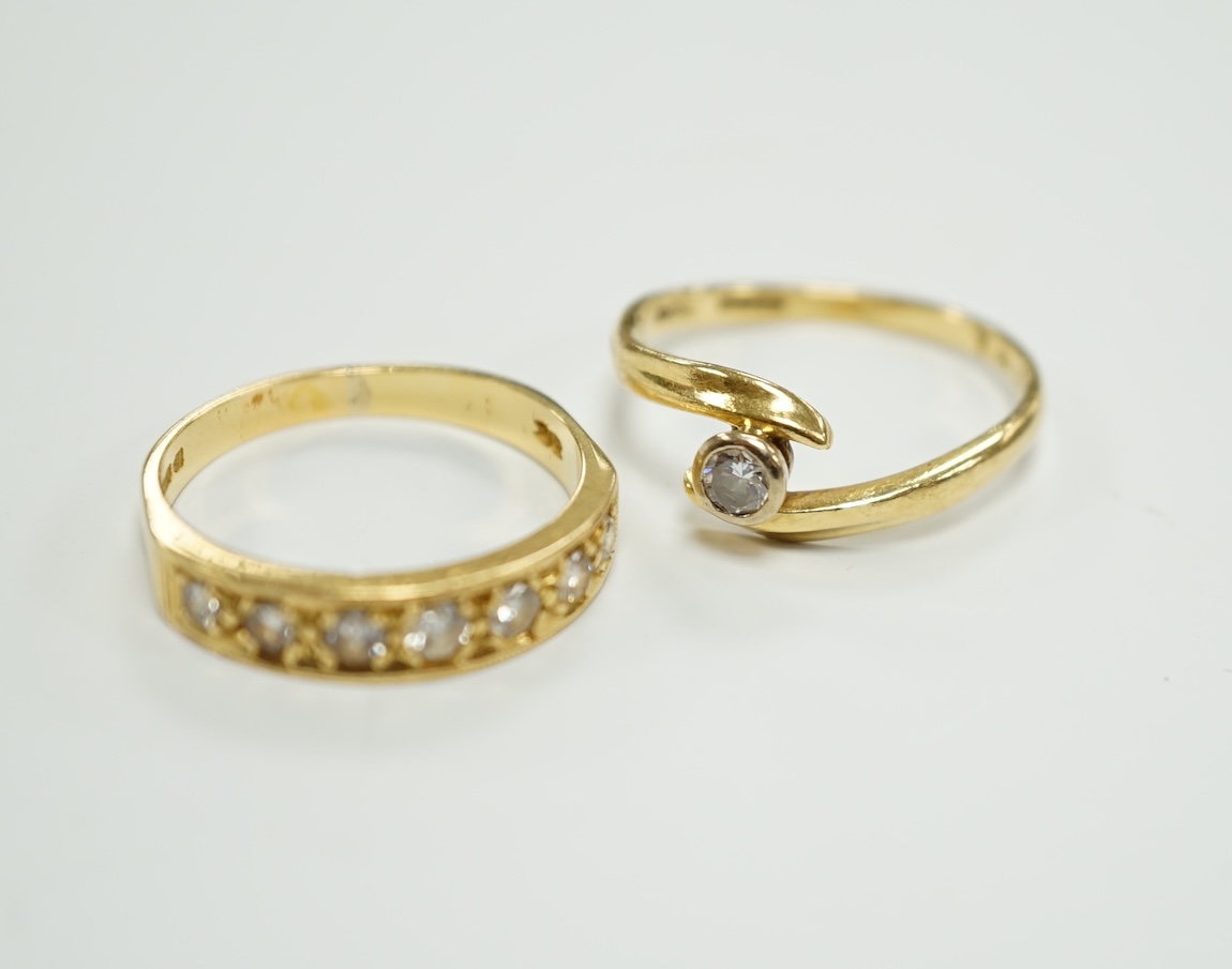 A modern 18ct gold and graduated seven stone diamond set half hoop ring, size O and a similar solitaire diamond ring with crossover setting, gross weight 6.4 grams.